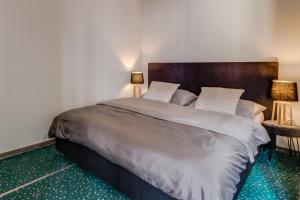 Hotel Maxim في فريدك-ميستيك: غرفة نوم بسرير كبير فيها مصباحين