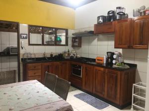 een kleine keuken met houten kasten en een tafel bij Casa Temporada da Dani in Paraty