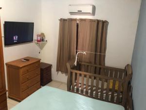 een kamer met een wieg en een televisie in een kamer bij Casa Temporada da Dani in Paraty