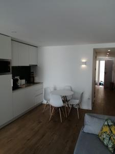 a kitchen and a living room with a table and chairs at CAIS DE APRESENTAÇÃO NO CORAÇÃO DE AVEIRO in Aveiro