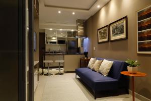 un soggiorno con divano blu e una cucina di #3 Sofisticado Estúdio na Boaventura Da Silva a Belém