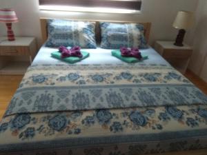 łóżko z dwoma fioletowymi łukami. w obiekcie Apartman Vesna w mieście Wiszegrad