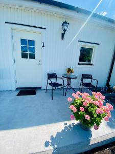 d'une terrasse avec une table, des chaises et une porte. dans l'établissement Enkegården Gårdshotell, à Ängelholm