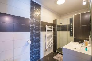 
a bathroom with a shower, sink, and mirror at Hotel La Riva in Siófok

