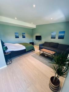 ein Schlafzimmer mit einem Bett und einem Sofa in der Unterkunft Enkegården Gårdshotell in Ängelholm