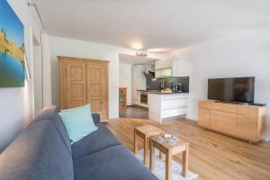 een woonkamer met een blauwe bank en een keuken bij Ferienwohnung Wanderbar in Oberstdorf