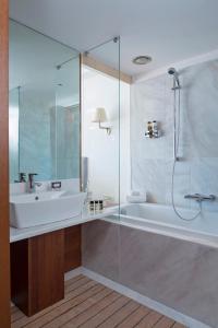 a bathroom with a tub and a sink and a shower at Horizon Blu Boutique Hotel in Kalamata