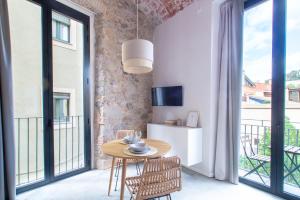 een kamer met een tafel en stoelen en een balkon bij Caelus Boutique Studio in Girona