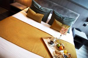 a bed with a tray of food on it at Icône Hôtel - Annecy in Annecy