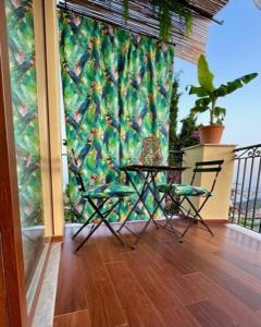 a patio with a table and two chairs on a balcony at Charme House Taormina in Taormina +21 photos