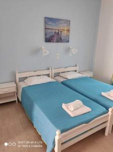 sypialnia z 2 łóżkami i ręcznikami w obiekcie lina studios w mieście Mesongi