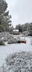 un parque cubierto de nieve con un banco y un edificio en Lomas de Berna en Villa Berna