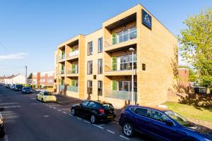 a building with cars parked on the side of a street at Premier Apartments in Gillingham in Gillingham