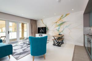 a living room with blue chairs and a marble wall at Medway contractor base for summer projects - Apartment 3 in Gillingham
