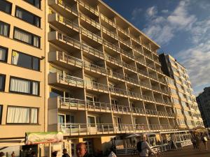 een groot appartementencomplex met mensen die er buiten staan bij "Puerto Cristo G2" - Modern Studio with Seaview in Oostende