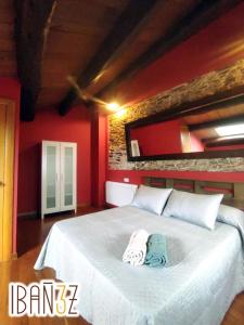 a bedroom with a large white bed with red walls at Ibañez 3 in Ribadeo