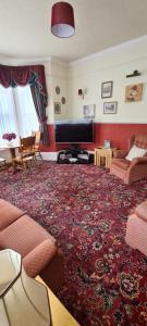 a living room with a couch and a flat screen tv at Beach Cottage in Shanklin