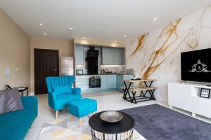 een woonkamer met een blauwe bank en een tv bij Medways Finest Accommodation in Gillingham