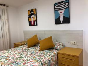 1 dormitorio con 1 cama y 2 cuadros en la pared en O LAR DO LUME en Porriño