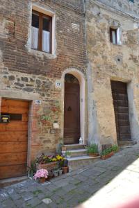 een bakstenen gebouw met een deur en wat bloemen bij Rocci al 17 in Montalcino