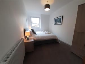 a bedroom with a bed and a desk and a window at Carvetii - Jade House - 3 bed House sleeps up to 8 in Kelty