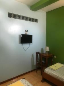 a room with a tv and a bed and a table at Amazon Dream Hostel with AC and Starlink in Iquitos +30 photos