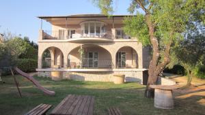a large house with a playground in front of it at Natasa apartments Krk in Vrh