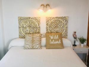 1 dormitorio con 1 cama con cabecero dorado en Apartamentos Ulia, en Benidorm