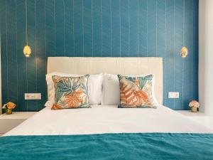1 dormitorio con 1 cama con sábanas y almohadas blancas en Alojamento Batata, en Nazaré