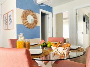 a dining room with a glass table with a bowl of fruit at Alojamento Batata in Nazaré +18 photos