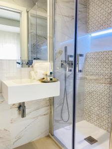 a bathroom with a white sink and a shower at Alojamento Batata in Nazaré