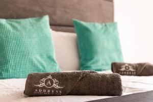 a towel on top of a bed with green pillows at Stay for Work - Spotless and Stress-Free - Apartment 5 in Gillingham +35 photos