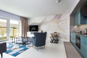 a living room with a kitchen with blue cabinets at NeuConnect contractor base near Grain - Apartment 5 in Gillingham