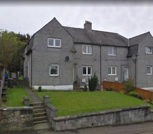 a large house with a grass yard in front of it at Carvetii - Jade House - 3 bed House sleeps up to 8 in Kelty