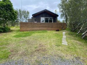 mały domek na wzgórzu z trawnikiem w obiekcie Cabin in the lava. Near Húsavík w mieście Skogar