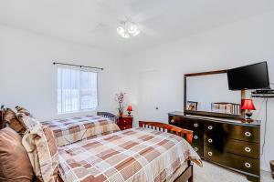a bedroom with a bed and a dresser with a mirror at Tranquil Times in Palm Desert +16 photos