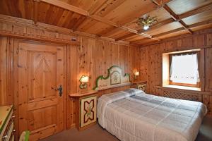 una camera con un letto in una stanza con pareti in legno di CASA LILI DOLOMITI, casa vacanze a Dosoledo a Dosoledo