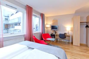 a hotel room with a bed and two chairs and a window at Thon Hotel Lillestrøm in Lillestrøm