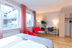 een hotelkamer met een bed en twee stoelen en een raam bij Thon Hotel Lillestrøm in Lillestrøm