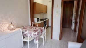 een kleine keuken met een tafel en stoelen in een kamer bij APP. MARCOPOLO - 100mt dal mare in Lido di Jesolo
