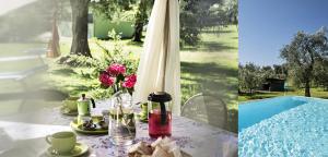 - une table avec de la nourriture et des fleurs à côté de la piscine dans l'établissement CAMPOLIVO ECOLODGES All HOUSE, à Gargnano