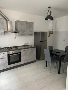 a kitchen with a stove and a table with chairs at Casa Turnone in Martina Franca