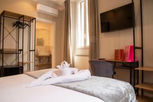 een slaapkamer met een bed met handdoeken erop bij AD Suites Tritone in Rome
