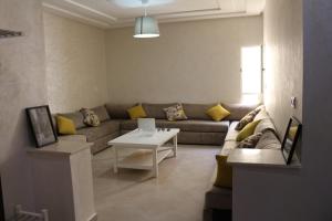 een woonkamer met een bank en een tafel bij Panorama Apartment Nador Jadid Klima free Parking & Wifi in Nador