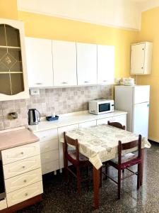 a kitchen with a table and chairs and a refrigerator at Delicious House Genova in Genova
