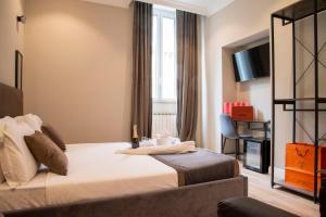 ein Hotelzimmer mit einem Bett und einem Stuhl in der Unterkunft AD Suites Tritone in Rom