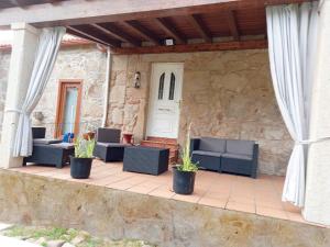 un patio con sofás y plantas en una pared de piedra en O Cobo vacacional en A Coruña
