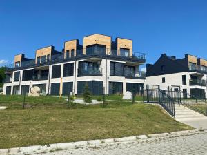 a large white building with a black roof at Apartament Panorama Park***** in Jelenia Góra