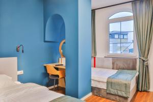 Schlafzimmer mit einem Bett, einem Schreibtisch und einem Fenster in der Unterkunft Benelux Hotel in Peja