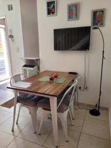 mesa de comedor con sillas y TV de pantalla plana en Departamento Argibay en Cipolletti